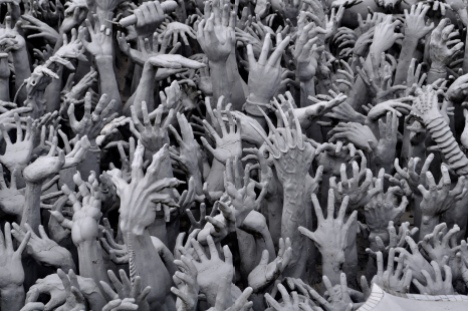 Hands clawing their way to the surface at Wat Rong Khun